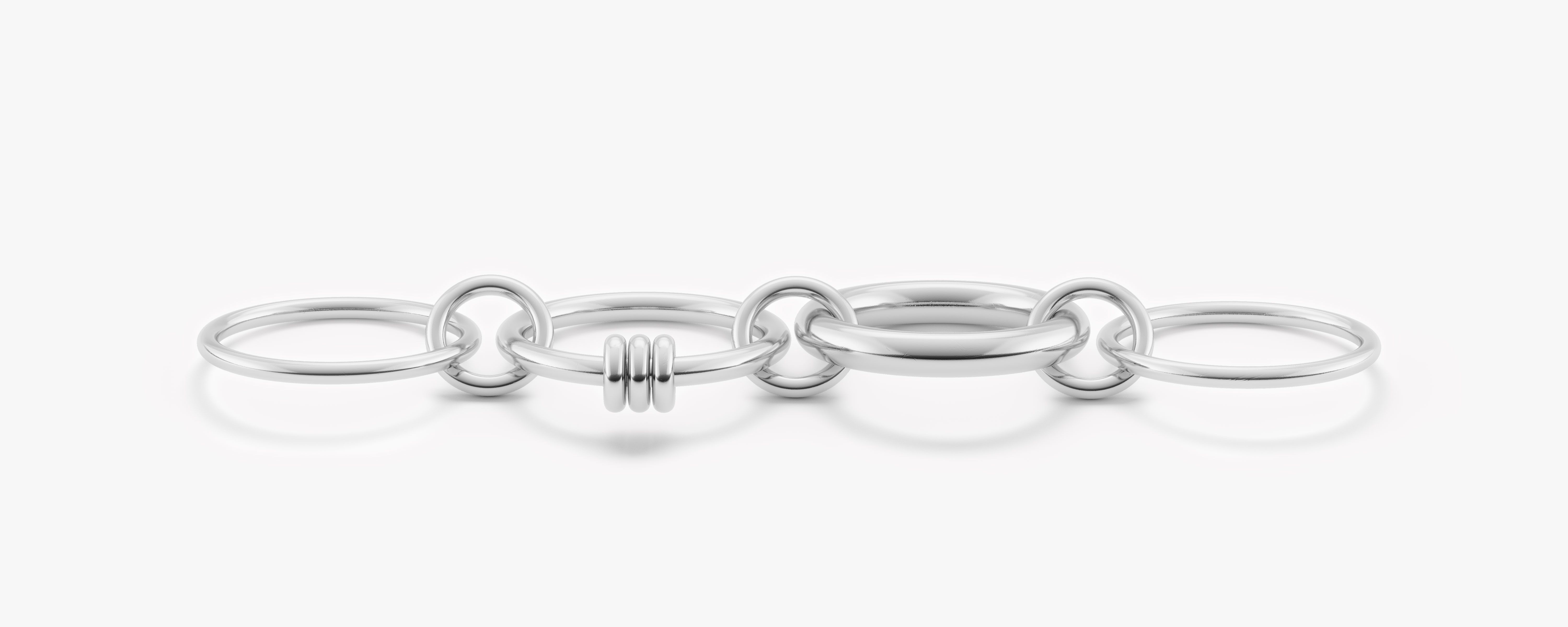 Spinelli Kilcollin rendering of the Aries Core Silver, four linked rings in silver spread out across a blank white background with light shadows beneath