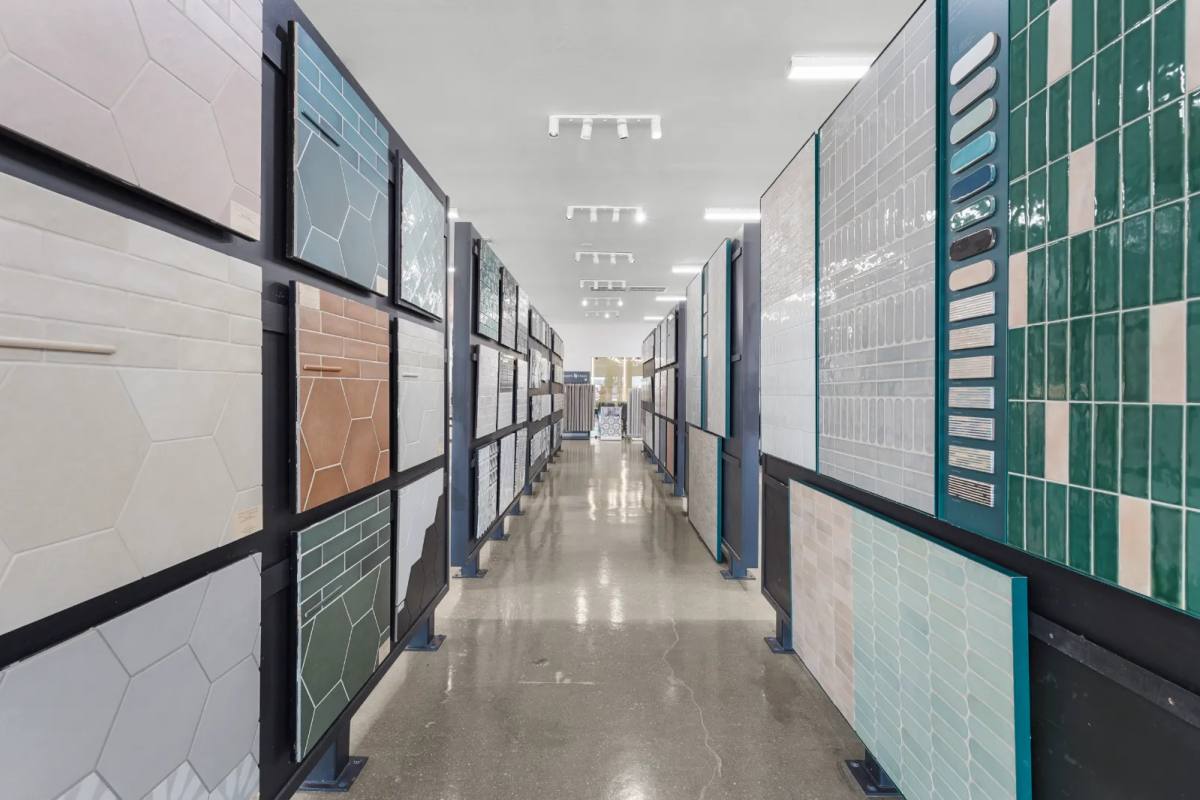 Large-format porcelain panels racked upright, floor to ceiling, in the SRQ Modern showroom