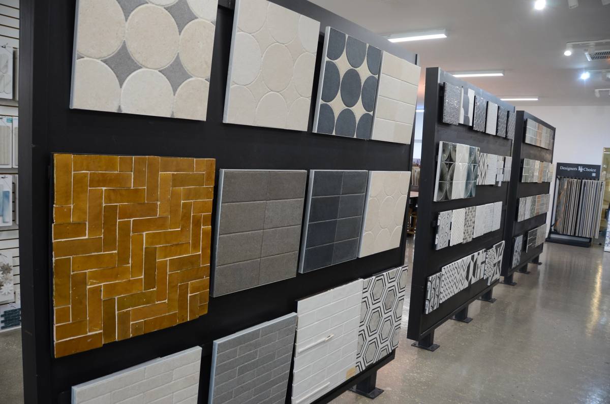Wall of three-dimensional relief tiles — mustard herringbone beside white sculptural forms