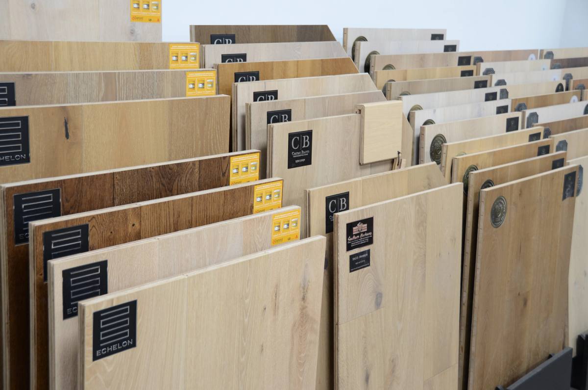 Engineered wood and plank samples stacked upright in the showroom racks with their spec cards