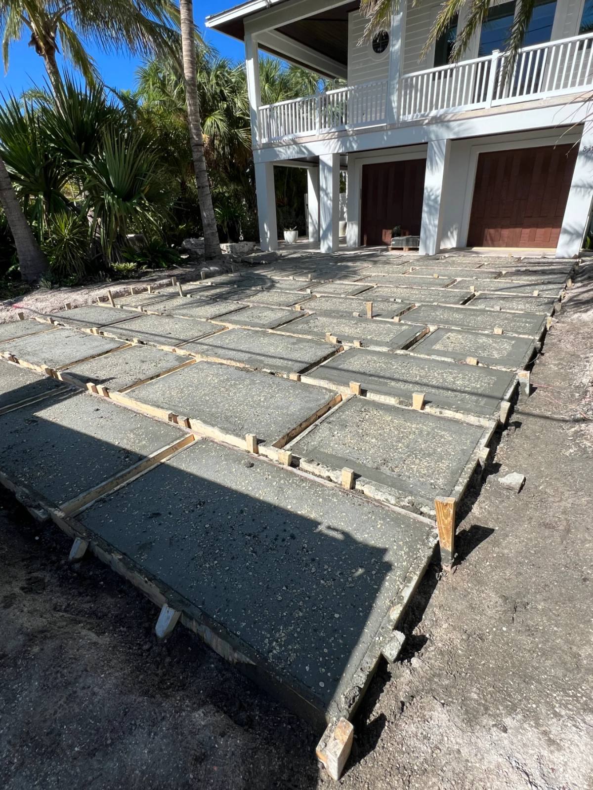 A grid of freshly poured Shellcrete driveway panels still in their timber formwork