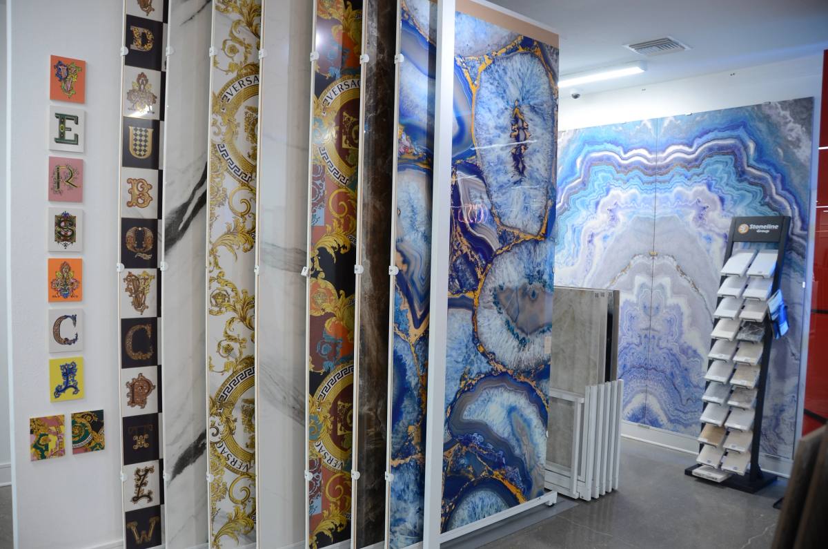 Decorative porcelain panels on the showroom wall — ornate prints beside a blue agate slab