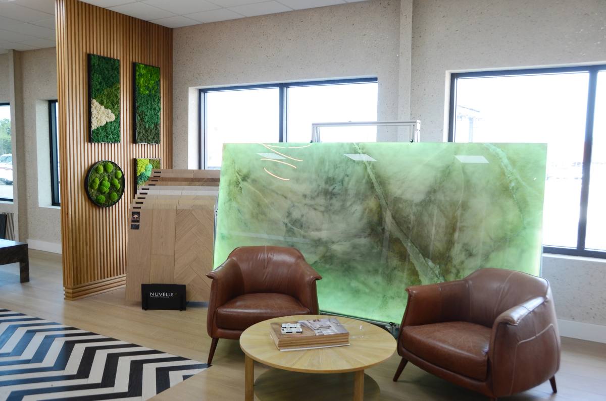 The Riva Spain lounge at the Bradenton showroom — leather armchairs facing a backlit green onyx slab