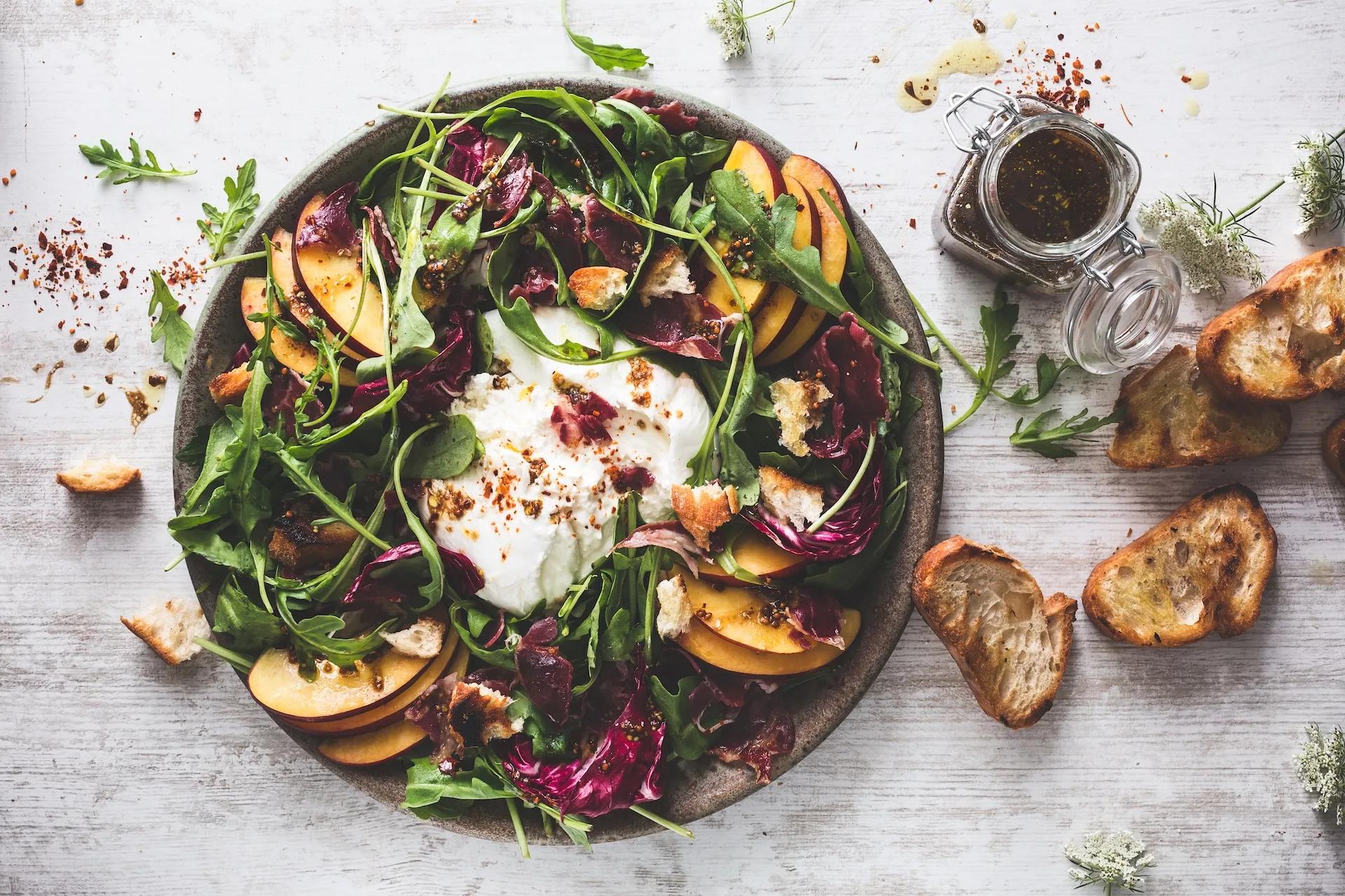 Grilled Peaches Burrata Recipe|Grilled fruit salad with peaches on a plate. White background.