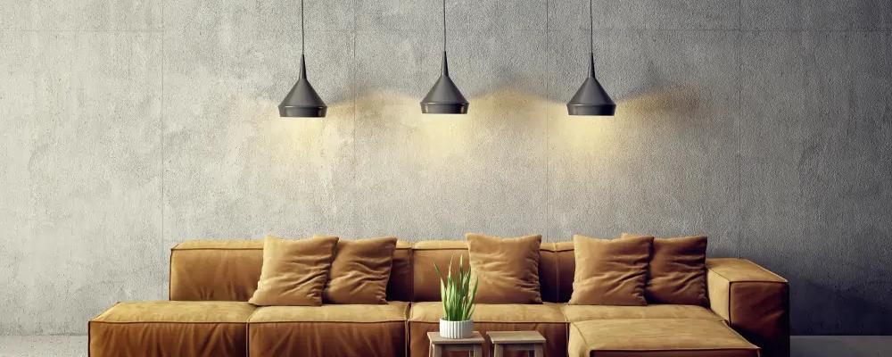 three lights hang from ceiling over a brown sofa