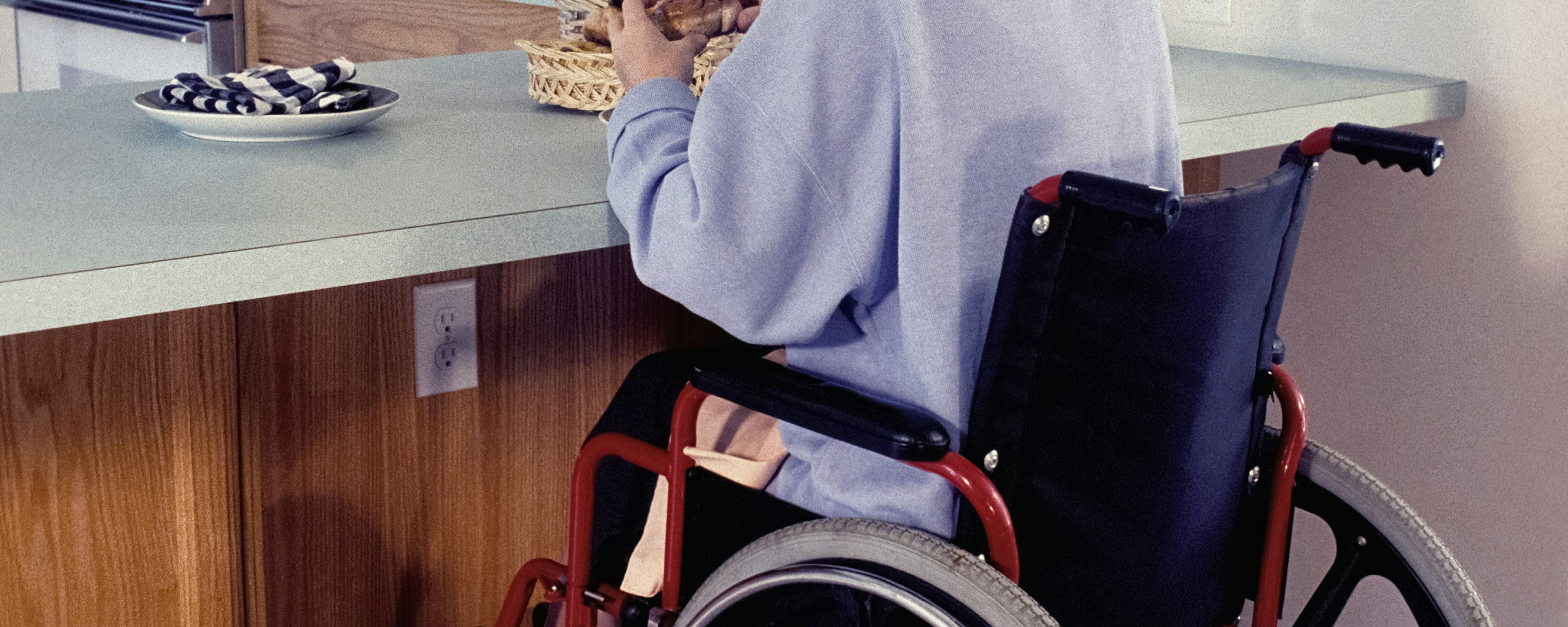 woman sitting in wheelchair eating at counter