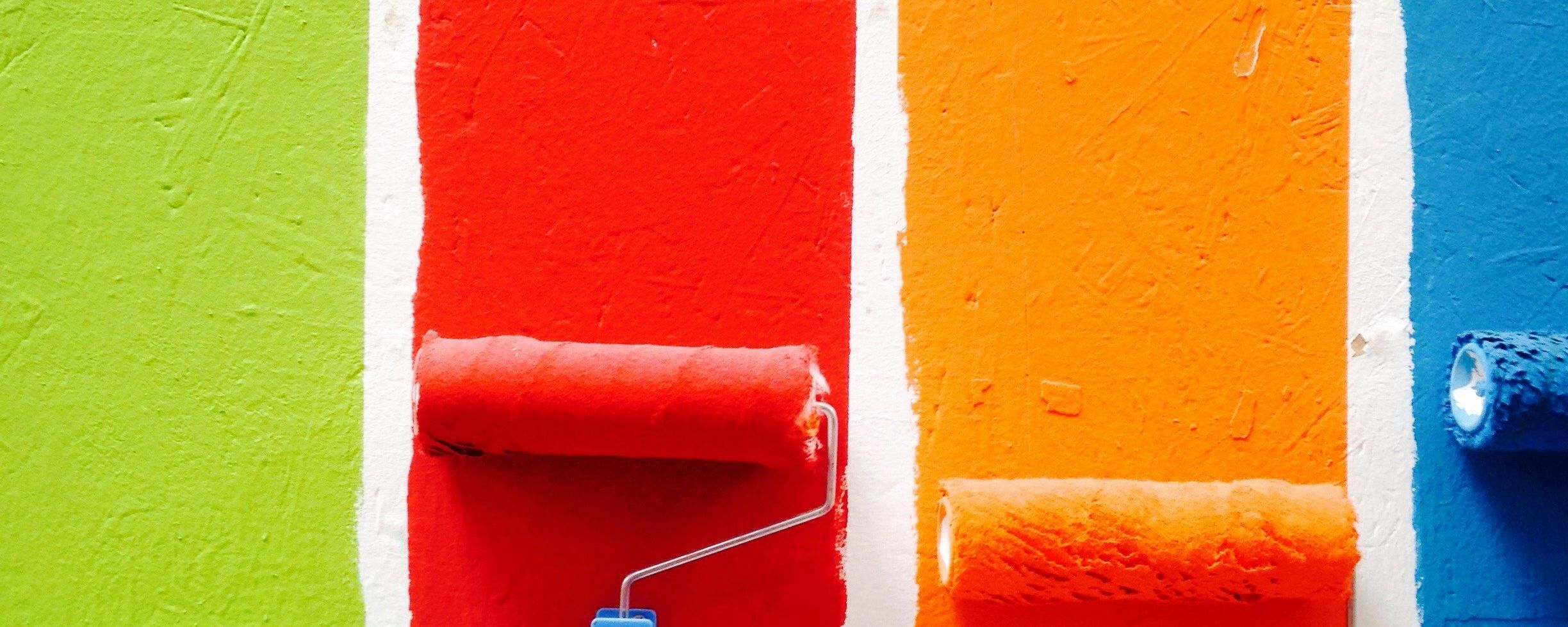 paint rollers with four different colors of paint