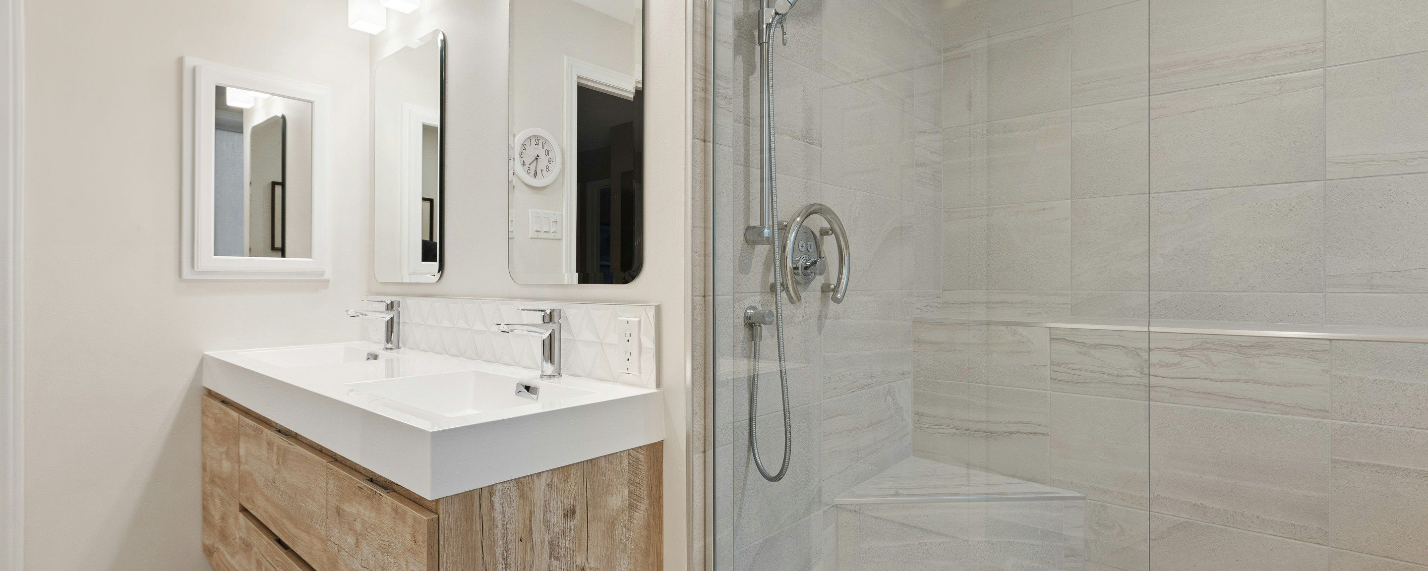 a bathroom with two sinks and a walk in shower .