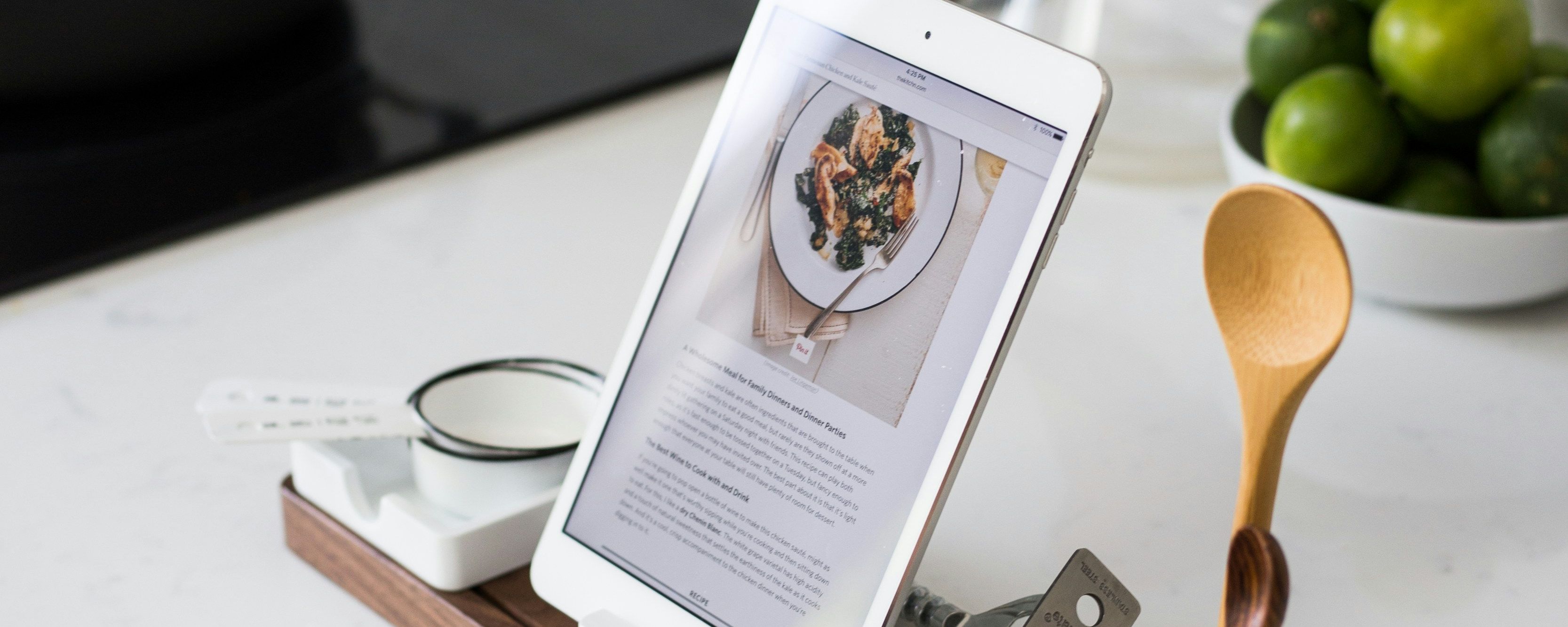 a tablet on a wooden tray with a recipe on it