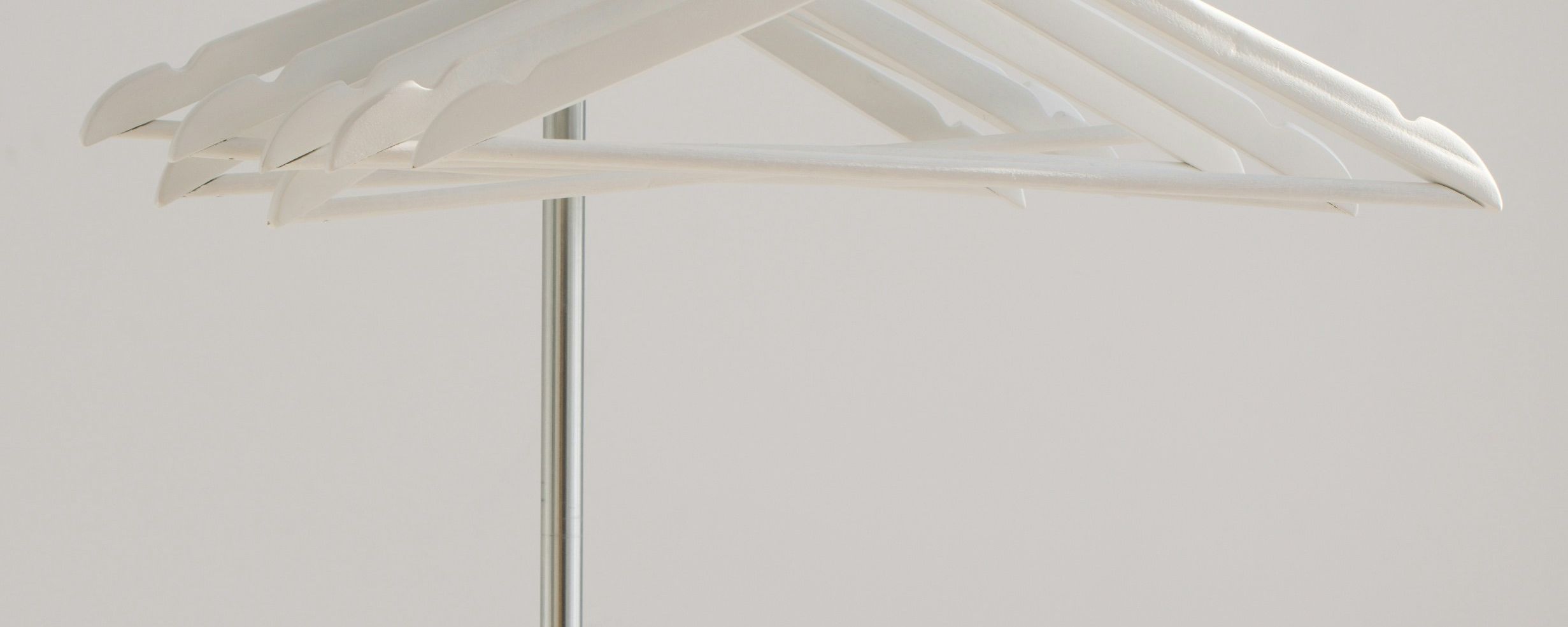 a bunch of white hangers hanging on a rack