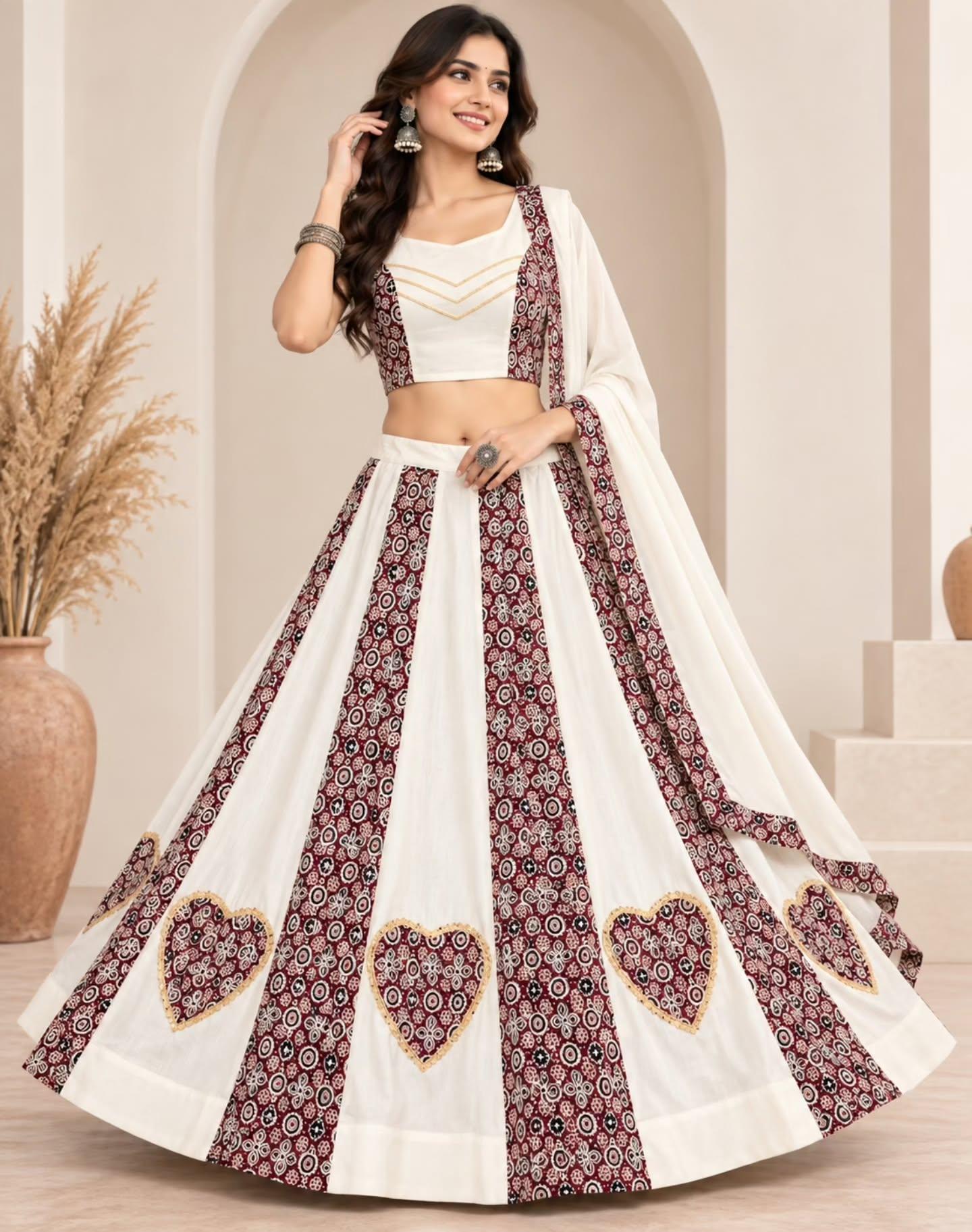 Model in an ivory and maroon chaniya choli with printed panels and heart motifs along the hem