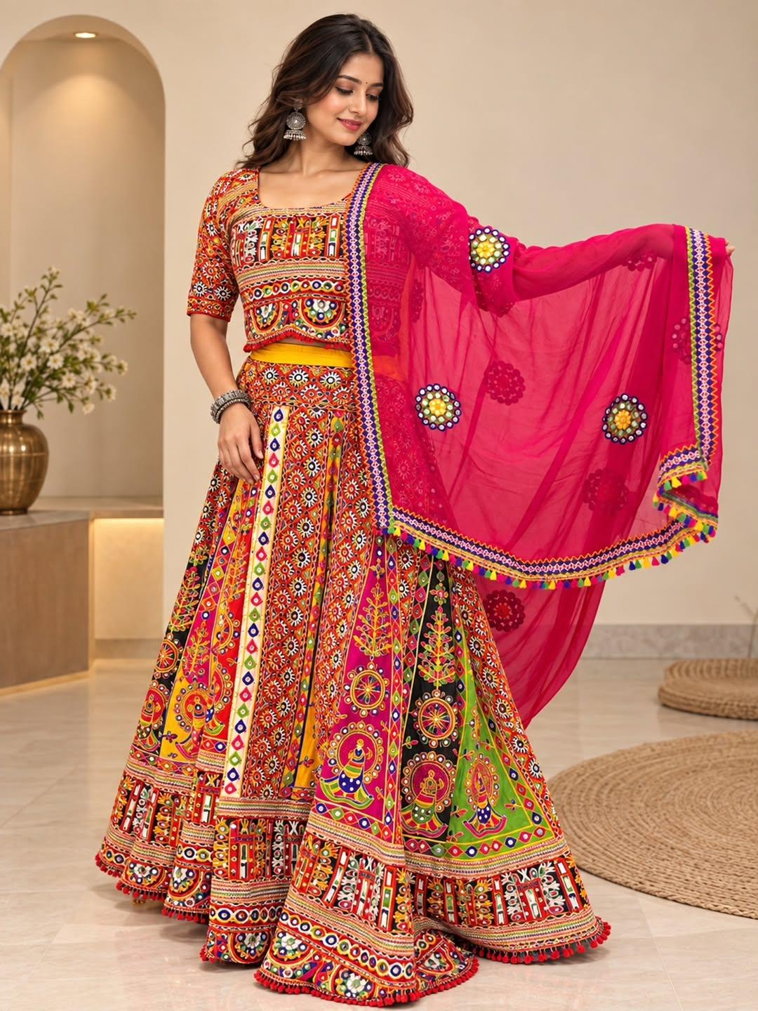 Model in a multicolour Gujarati-print chaniya choli with a pink choli and a pink mirror-work dupatta