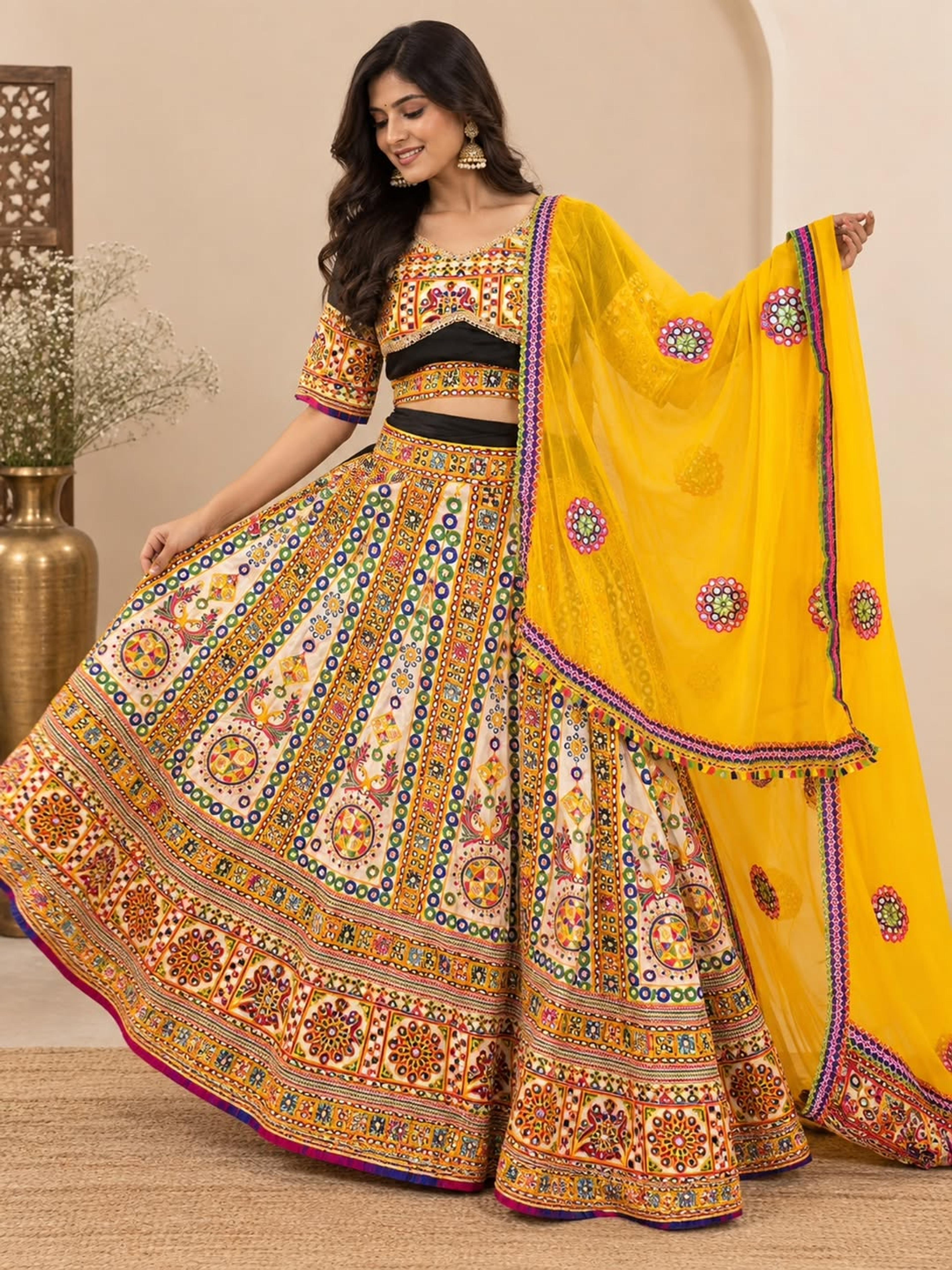 Model in a designer chaniya choli with vibrant traditional prints and a bright yellow dupatta