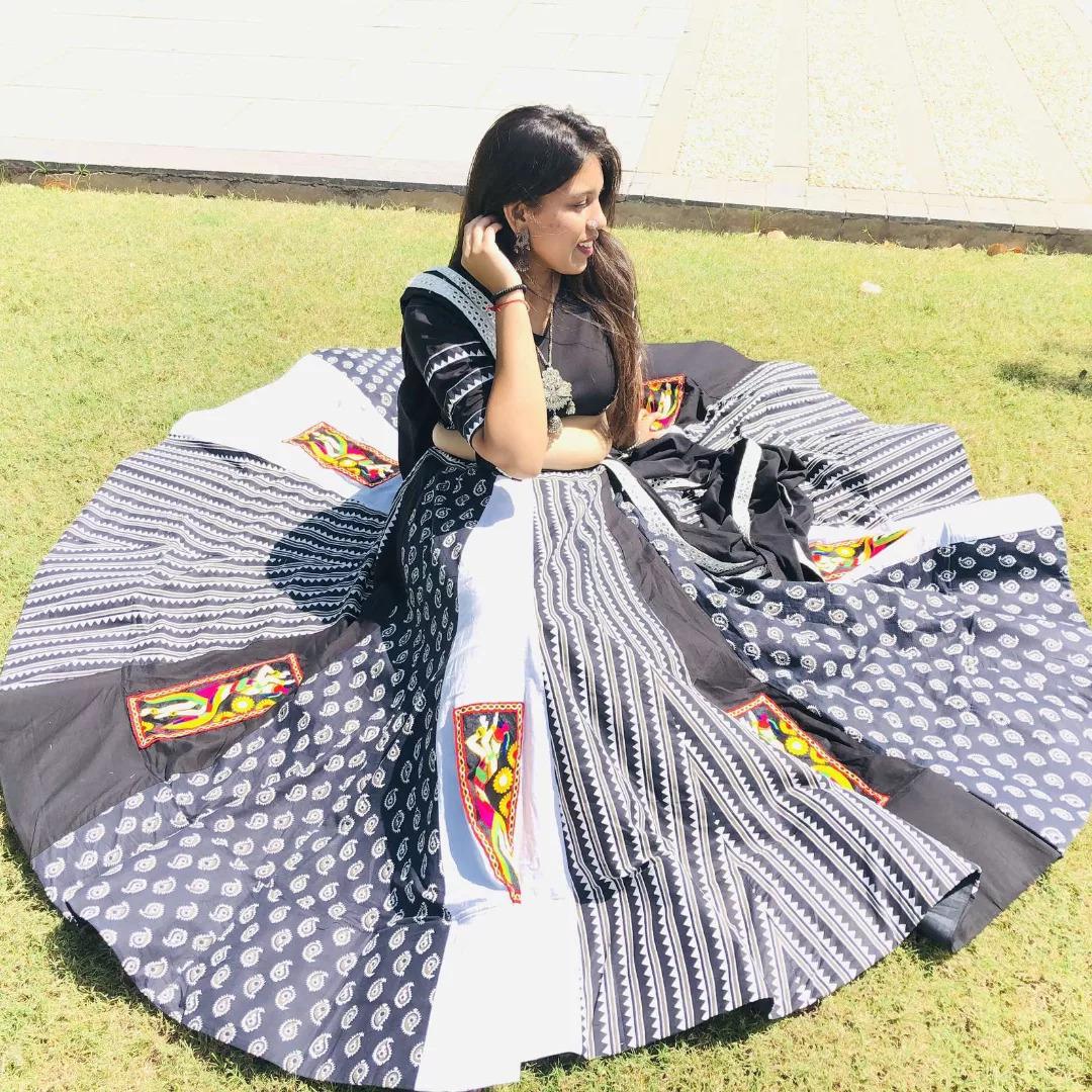 Black and white block print chaniya choli with colourful embroidered patches, spread on the grass