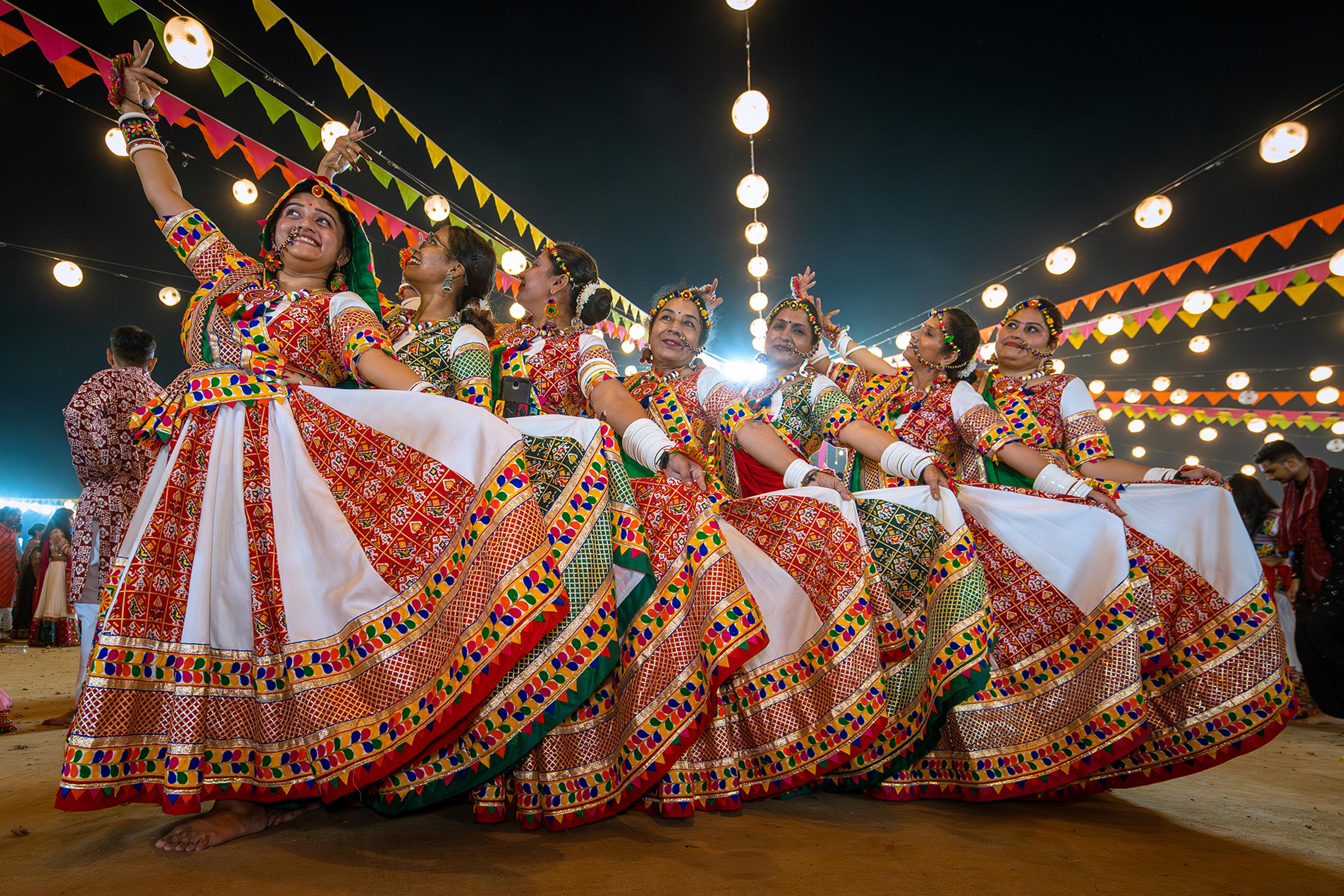 Women in chaniya choli twirling together at a Navratri Garba night