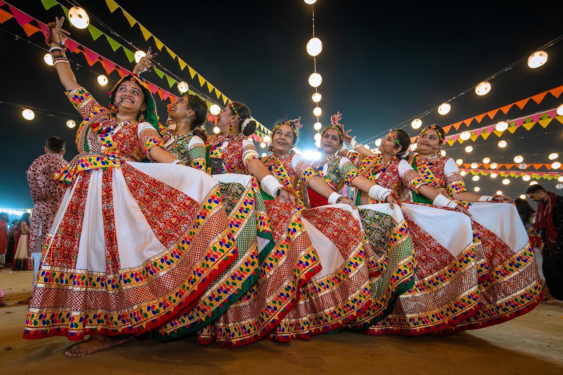 Women in chaniya choli twirling together at a Navratri Garba night