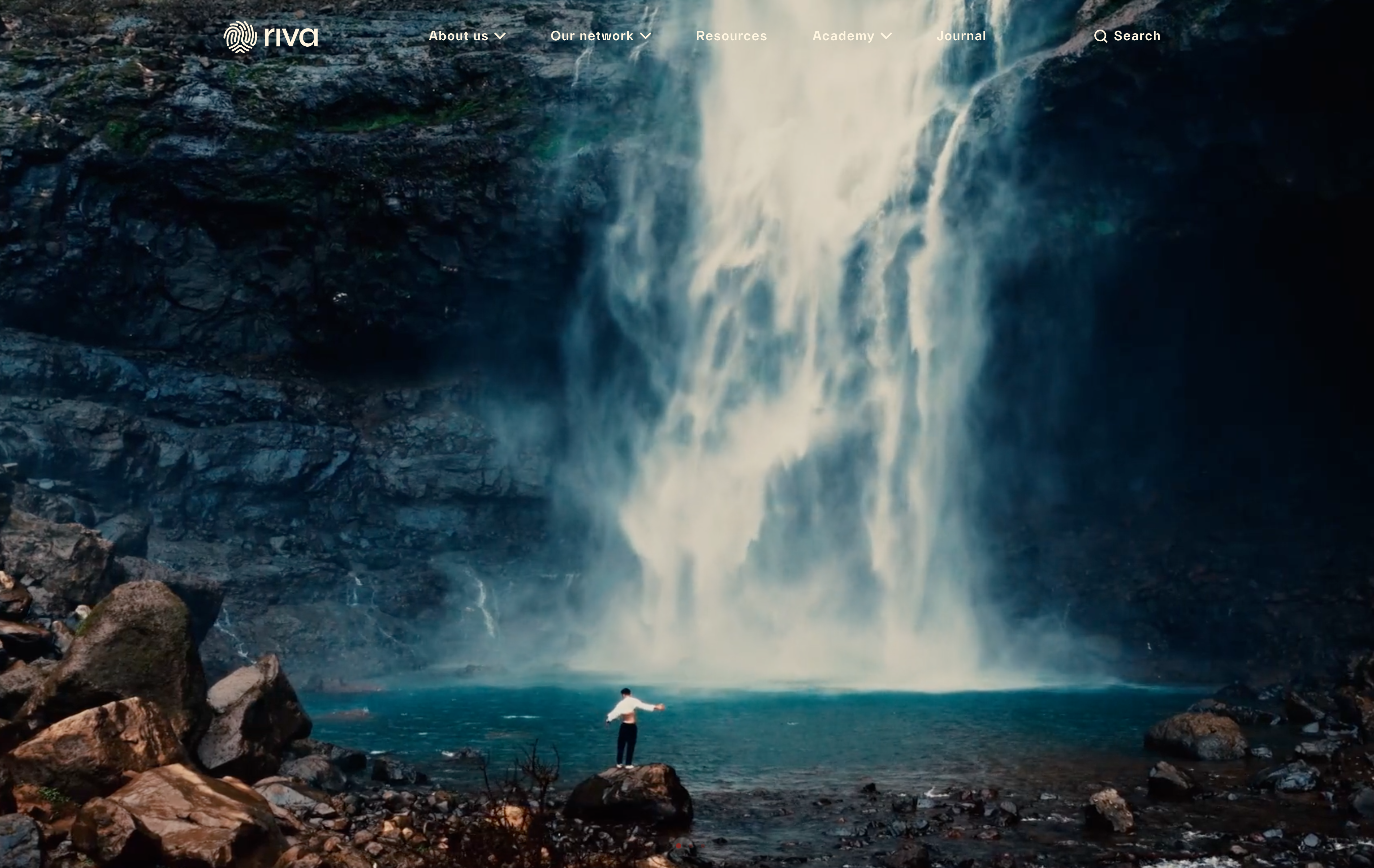 Man on rock in front of water with website menu above image