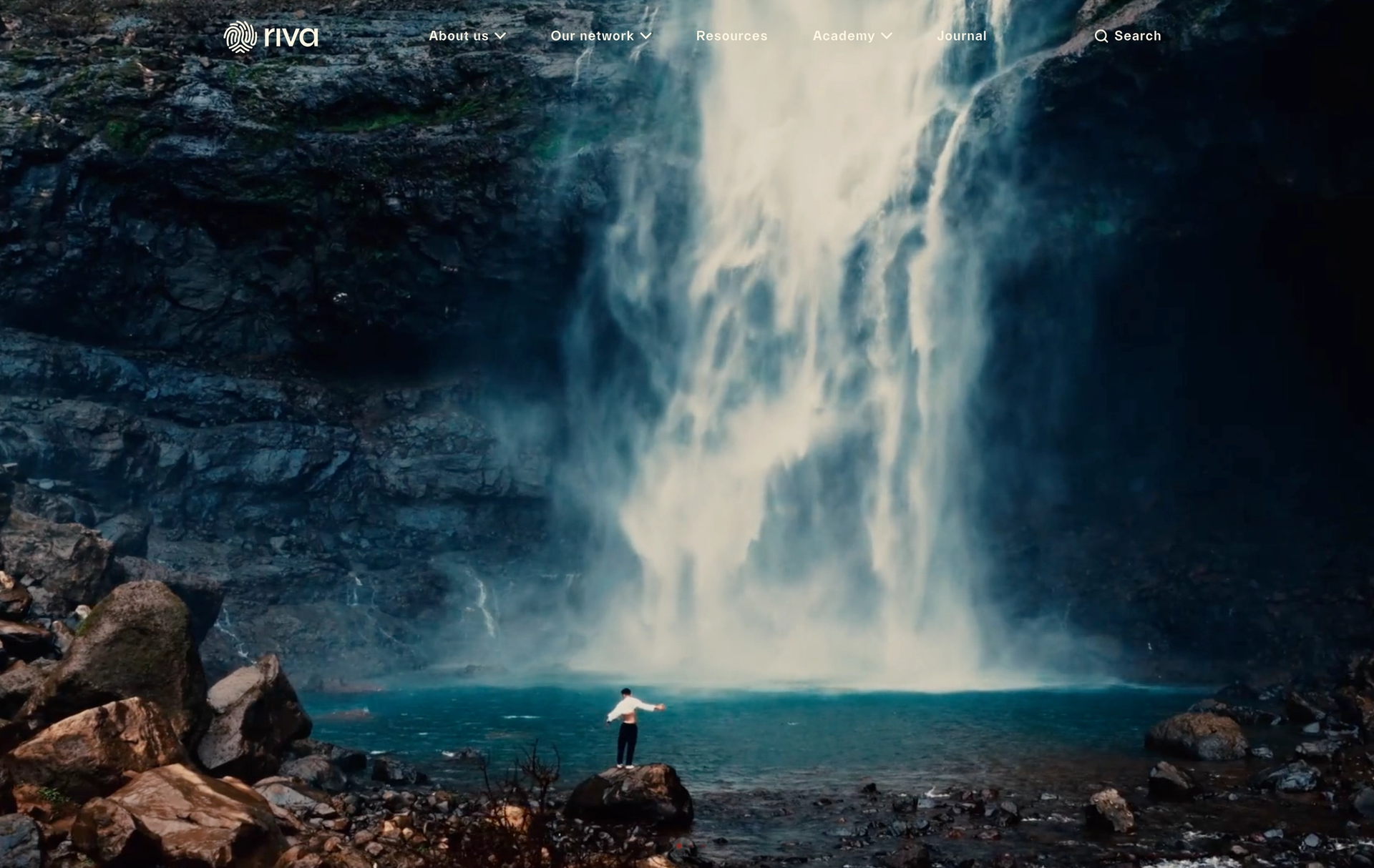 Man on rock in front of water with website menu above image