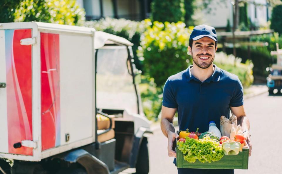 Delivery driver loading stock into a van, representing better control over van sales deliveries
