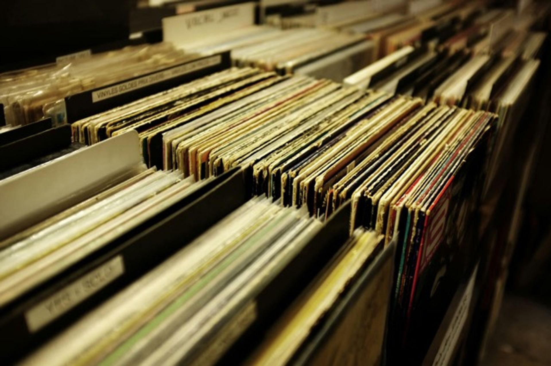 a shelf filled with lots of records in a record store .