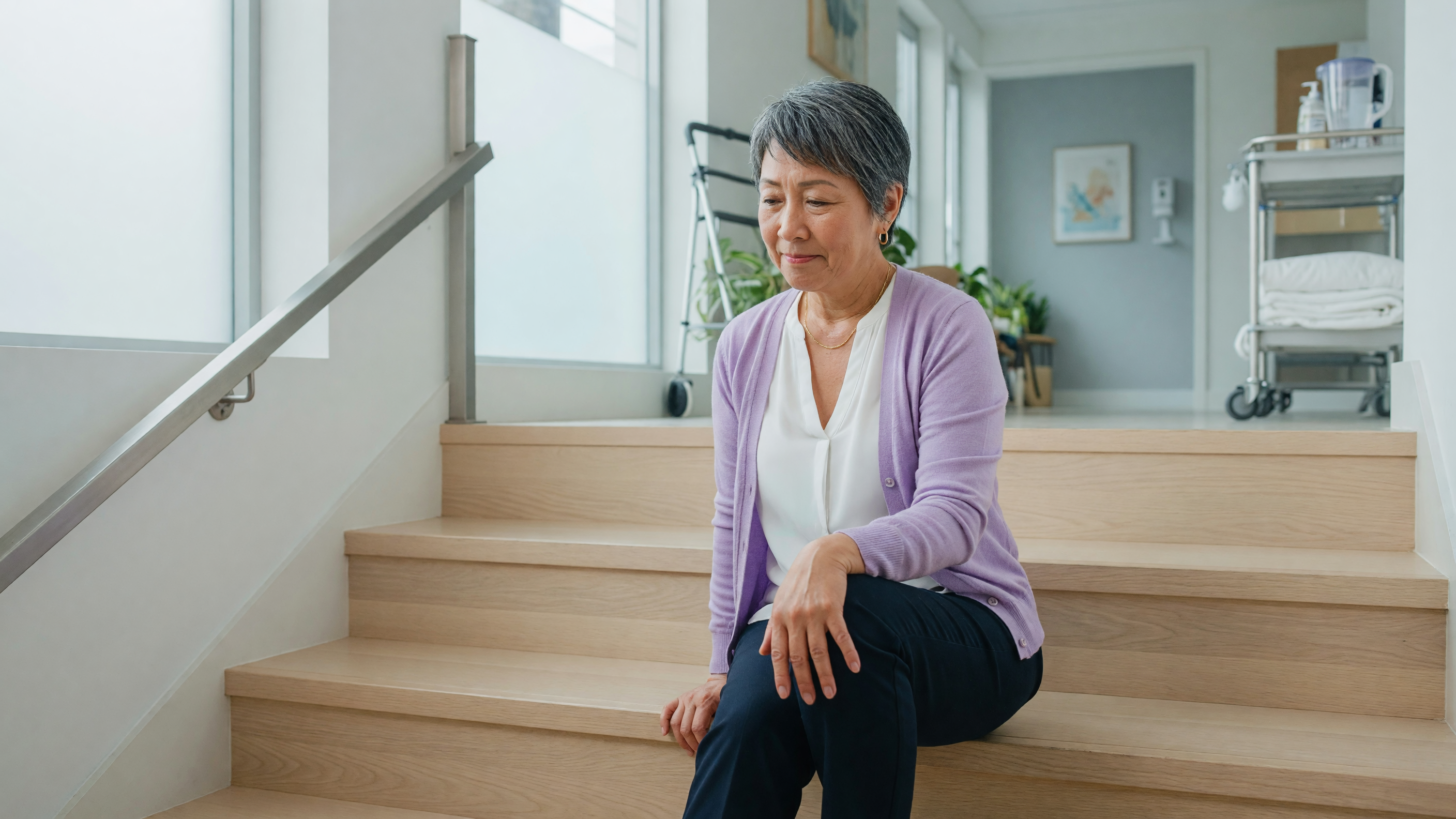 Person experiencing knee pain climbing stairs holding their knee
