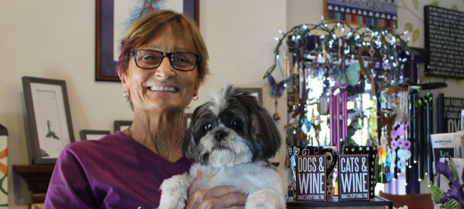 The photo shows Sue in her purple shirt with current pet named Beau.