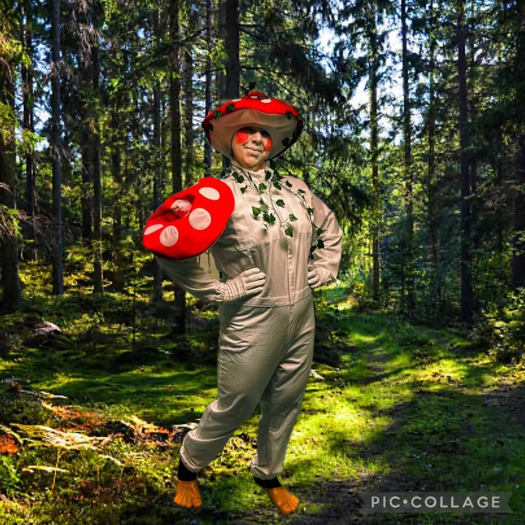 Maskoten Svampe, en svampfigur med röd hatt, i skogen