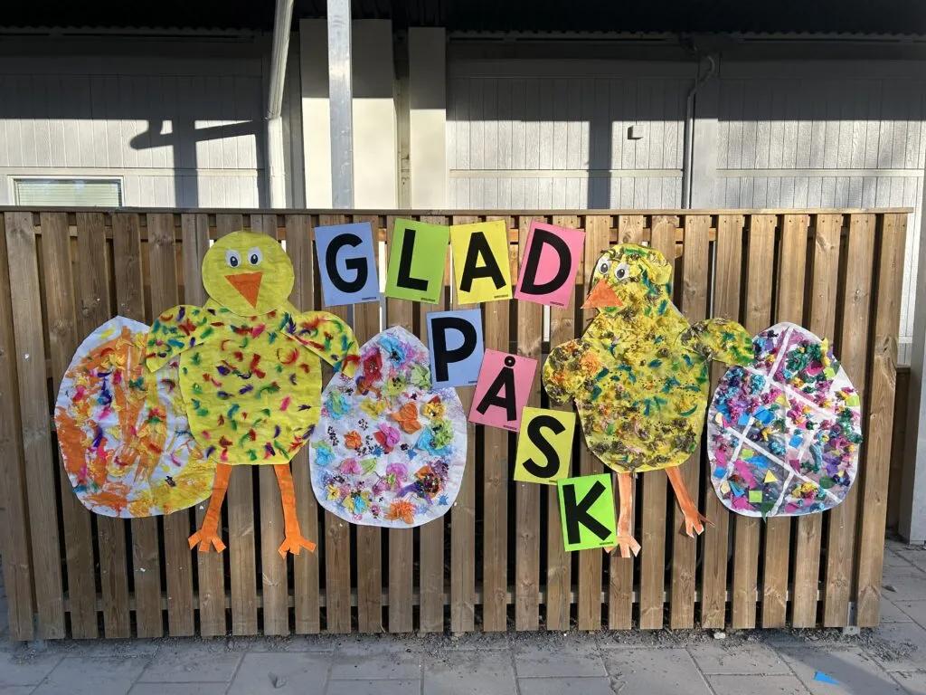 Glad påsk på gårdens staket: kycklingar och påskägg som barnen skapat