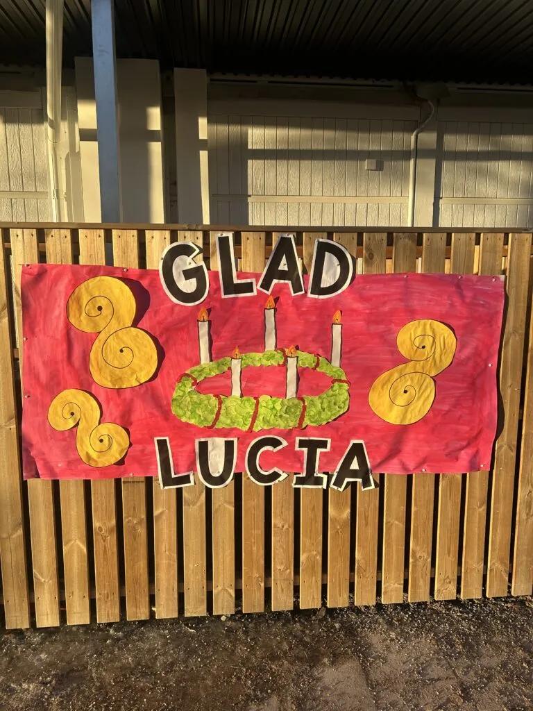 Glad Lucia-banderoll med luciakrona och lussekatter, målad av barnen