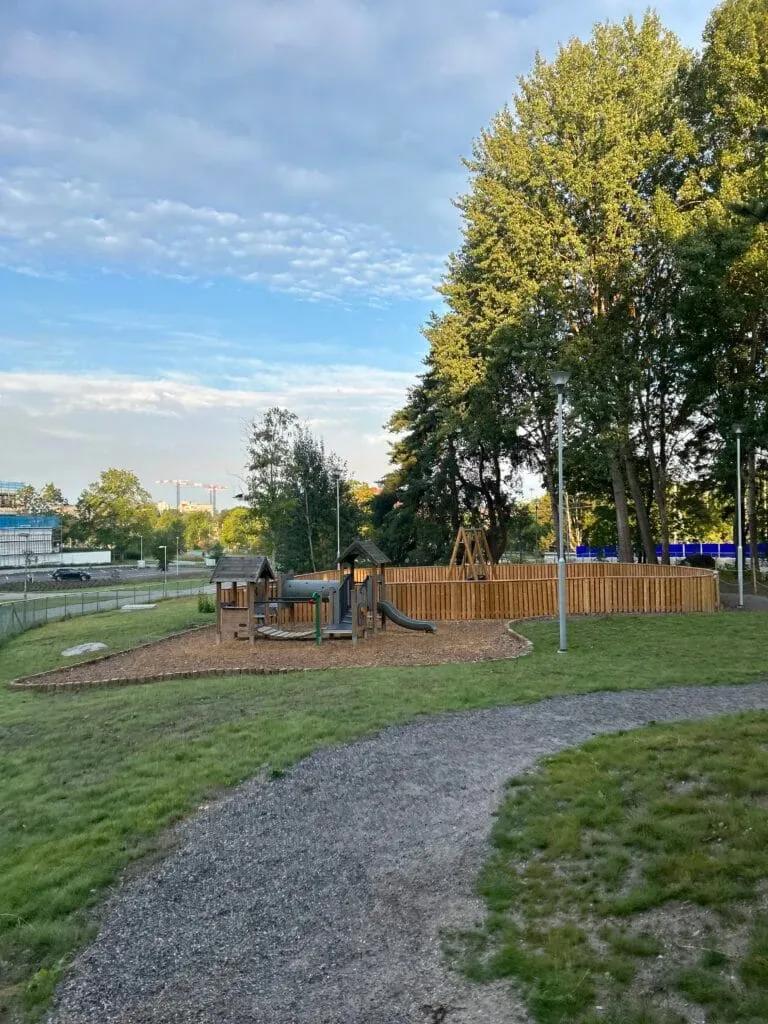 Gårdens lekstuga och rutschkana omgärdade av trästaket