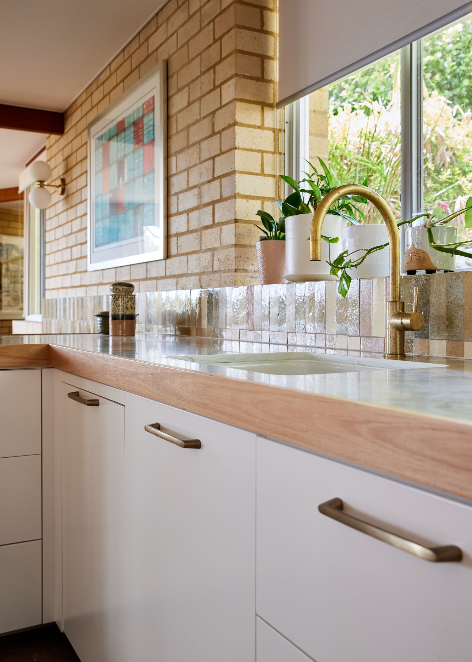 Kitchen bench with brass tap and cupboards