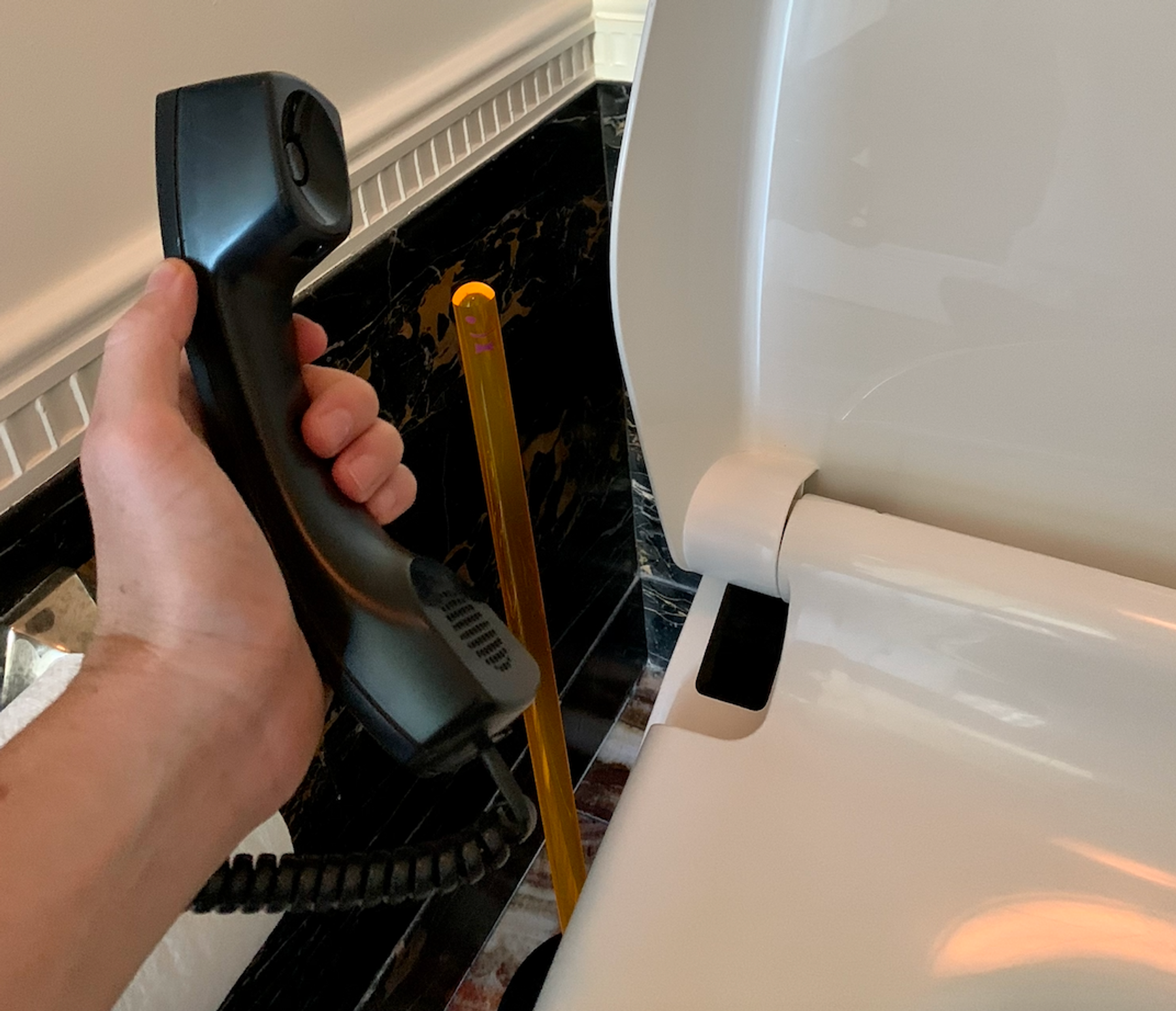 Orange plunger and hand with phone