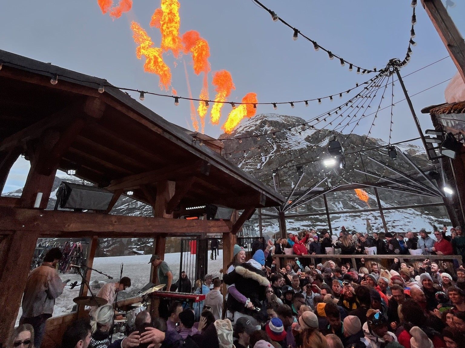 Crowd watches a fiery evening display at a busy alpine ski resort