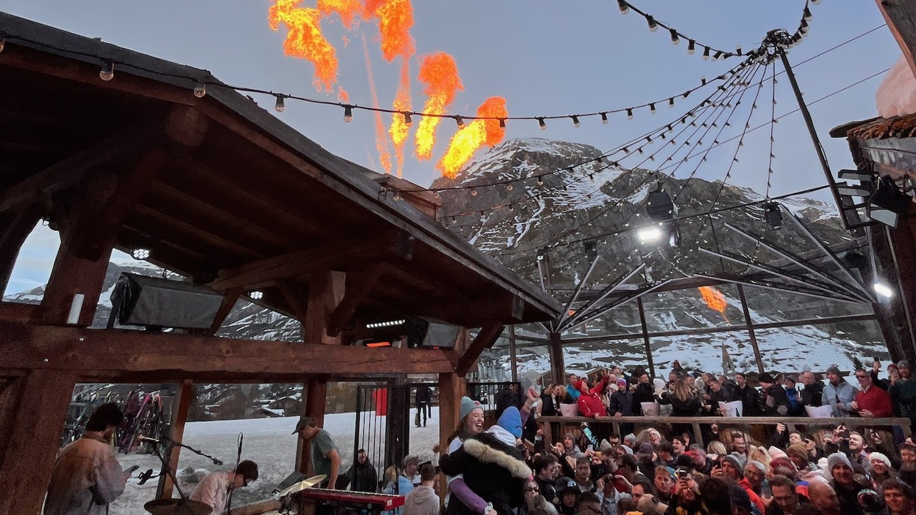 Crowd watches a fiery evening display at a busy alpine ski resort