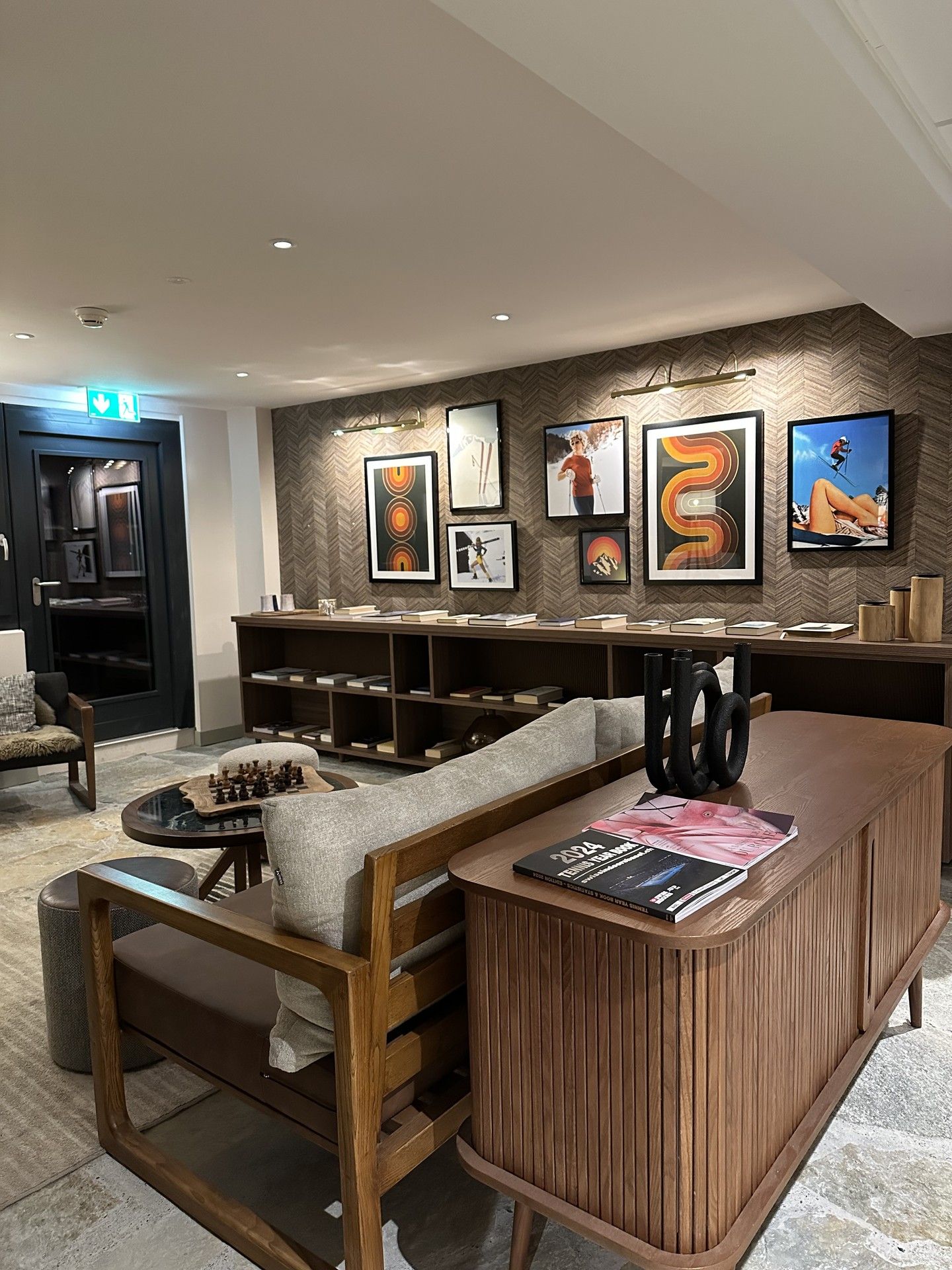 Modern ski lodge lounge with framed art, seating area, and coffee-table books
