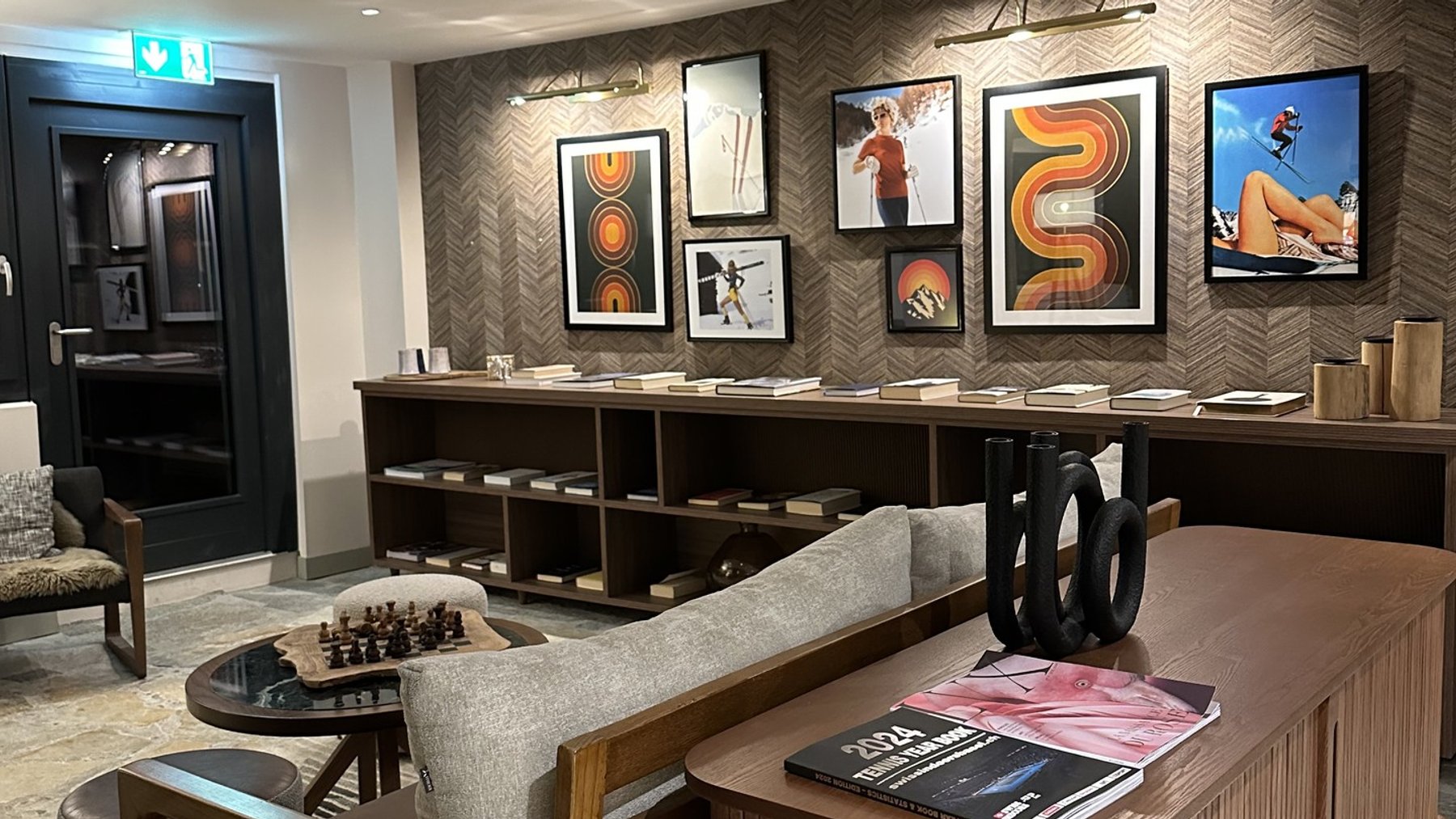 Modern ski lodge lounge with framed art, seating area, and coffee-table books