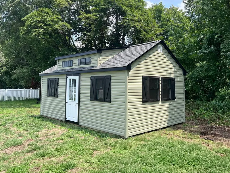 Sage green dormer shed with black shutters