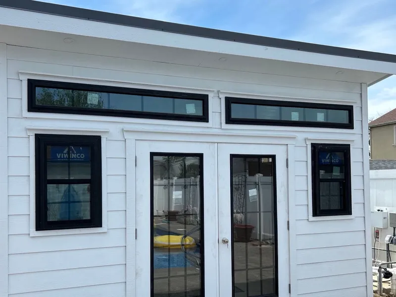 White pool house with French doors and a row of transom windows