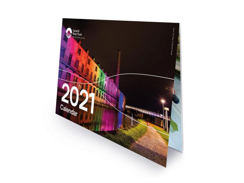 Canal & River Trust tent calendar showing the front face with a building next to a canal at night lit up with multicoloured lights with the title "2021 Calendar".