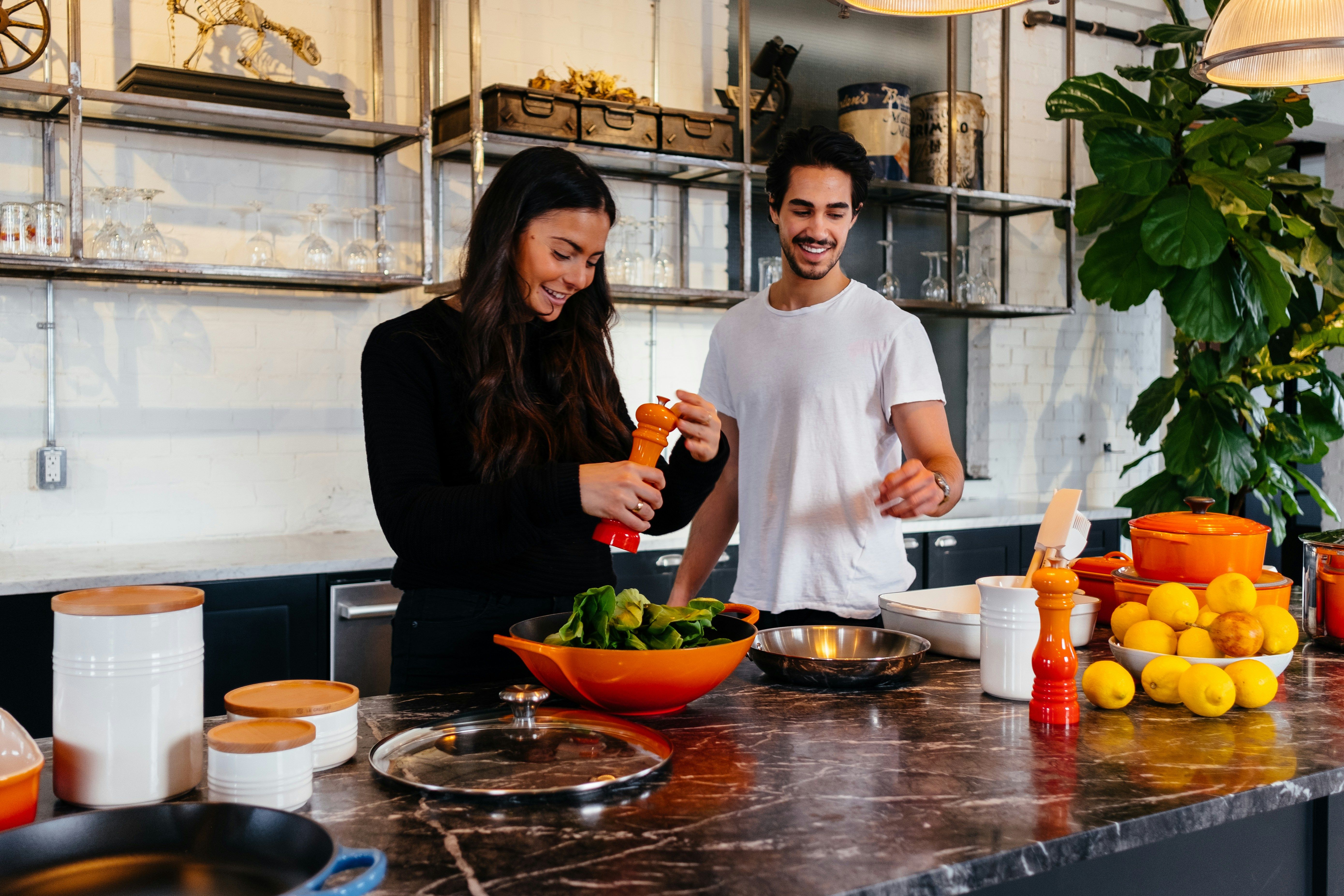 Two people prepare a healthy meal together in a bright kitchen.