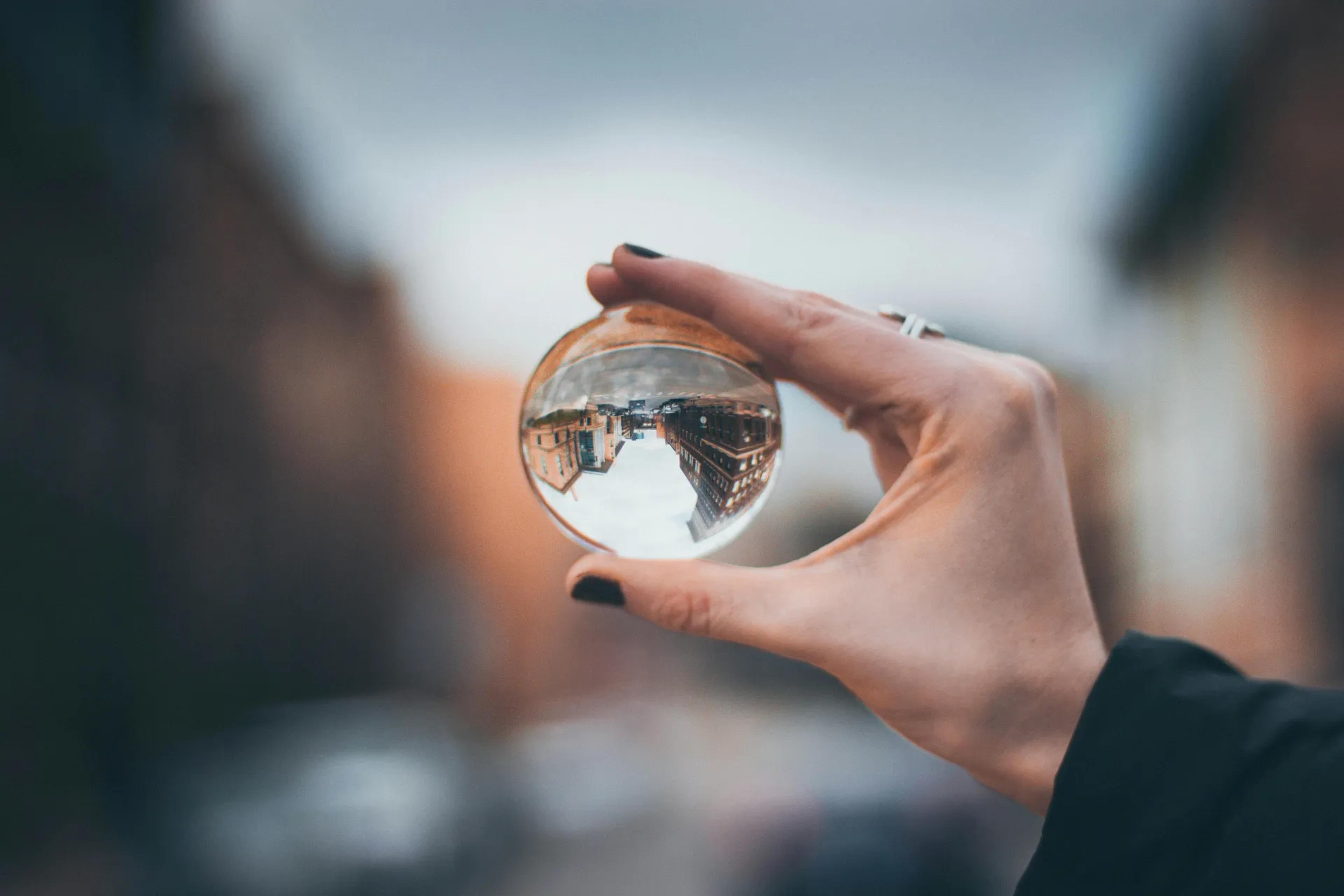 A hand holding a glass ball