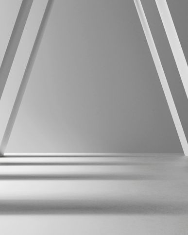 High-contrast architectural photograph of symmetrical, monolithic white concrete pillars angling inward to support a vaulted hallway ceiling, creating rhythmic patterns of sharp geometric shadows to visually represent the balanced, load-bearing operating partnership between the CMO and the CFO.