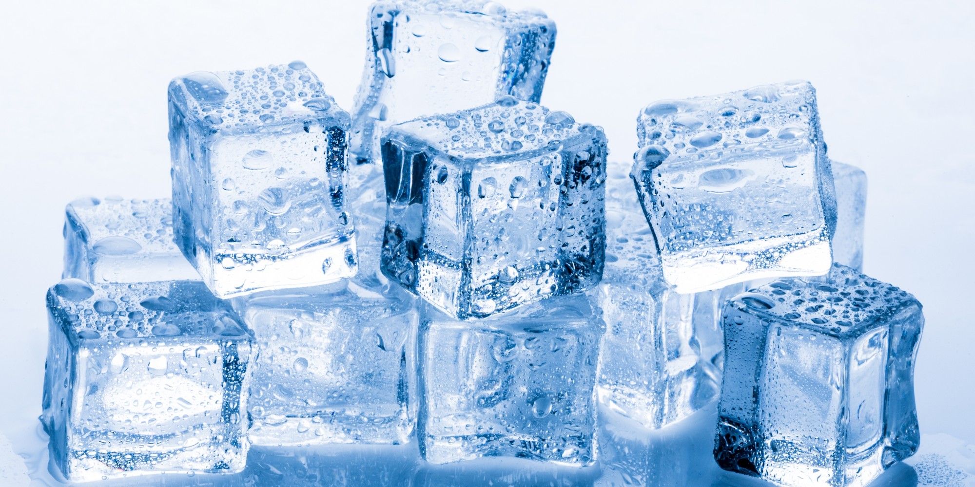 Several glistening, clear blue ice cubes stacked in a pile, beaded with condensation, slowly melting, representing anonymity that erodes over time.