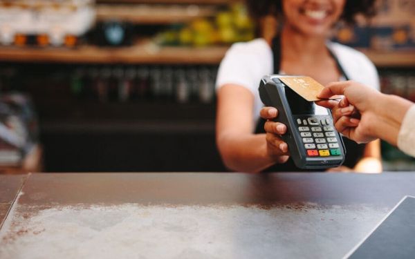 Customer making a card payment at an Irish café using a POS terminal — representing merchant services and merchant cash advance funding for Irish businesses