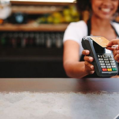Customer making a card payment at an Irish café using a POS terminal — representing merchant services and merchant cash advance funding for Irish businesses