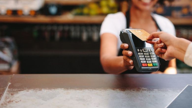 Customer making a card payment at an Irish café using a POS terminal — representing merchant services and merchant cash advance funding for Irish businesses