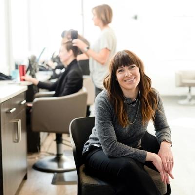 An infographic titled "Ways To Handle Weekly Repayment Business Loans Ireland (And Stay Flexible)" set against a background of an Irish city skyline and a green park with a stone bridge. A large shamrock icon on the right contains a stack of 100 Euro notes and gold coins. To the left, a list with shamrock bullet points presents six strategies: "Budgeting & Forecasting", "Negotiate Terms", "Emergency Fund", "Emergency Fund" (repeated), "Cash Flow Management", and "Flexible Options