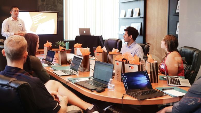 Business meeting, comparing backed loans versus standard loans for SMEs.