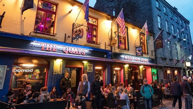 busy Irish pub with people socialising, reflecting Ireland’s community, tourism, and small-business support schemes available in 2026.