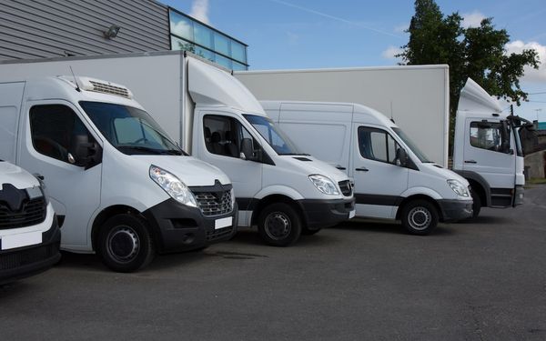 Fleet of white commercial vans parked outside Irish business premises — ideal for delivery companies seeking van finance, leasing, or fleet funding in Ireland